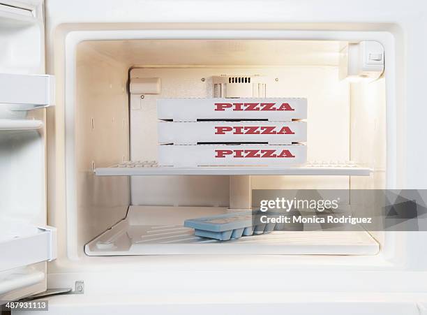 frozen pizza inside home freezer - gefrierschrank stock-fotos und bilder