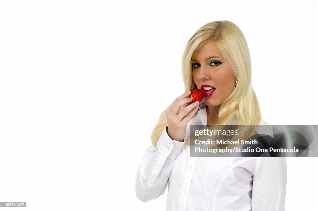 Blonde Female Eating a Strawberry