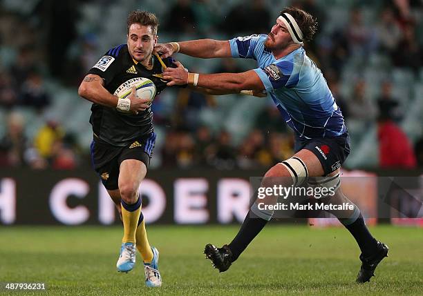 Andre Taylor of the Hurricanes evades the tackle of Kane Douglas of the Waratahs during the round 12 Super Rugby match between the Waratahs and the...