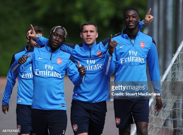Bacary Sagna, Lukas Podolski and Yaya Sanogo of Arsenal before a training session at London Colney on May 3, 2014 in St Albans, England.
