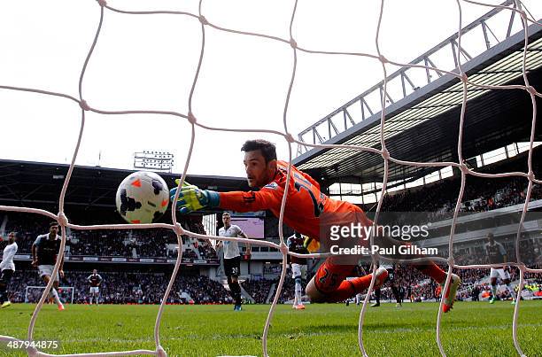 Goalkeeper Hugo Lloris of Spurs dives in vain as Stewart Downing of West Ham scores his team's second goal during the Barclays Premier League match...