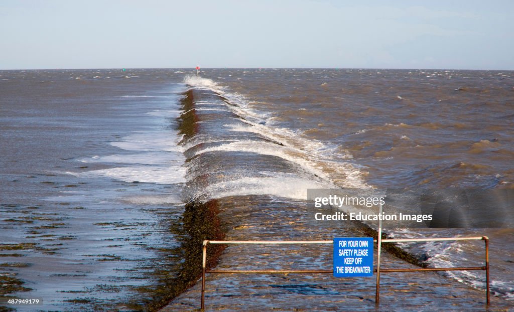 High seas forcing waves over the harbor mouth breakwater at Harwich, Essex, England