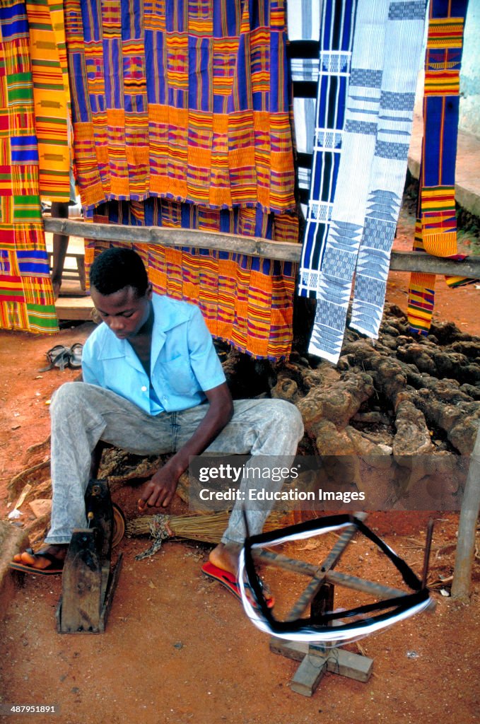 A weaver spins yarn and winds it onto bobbins to be used to make kente cloth