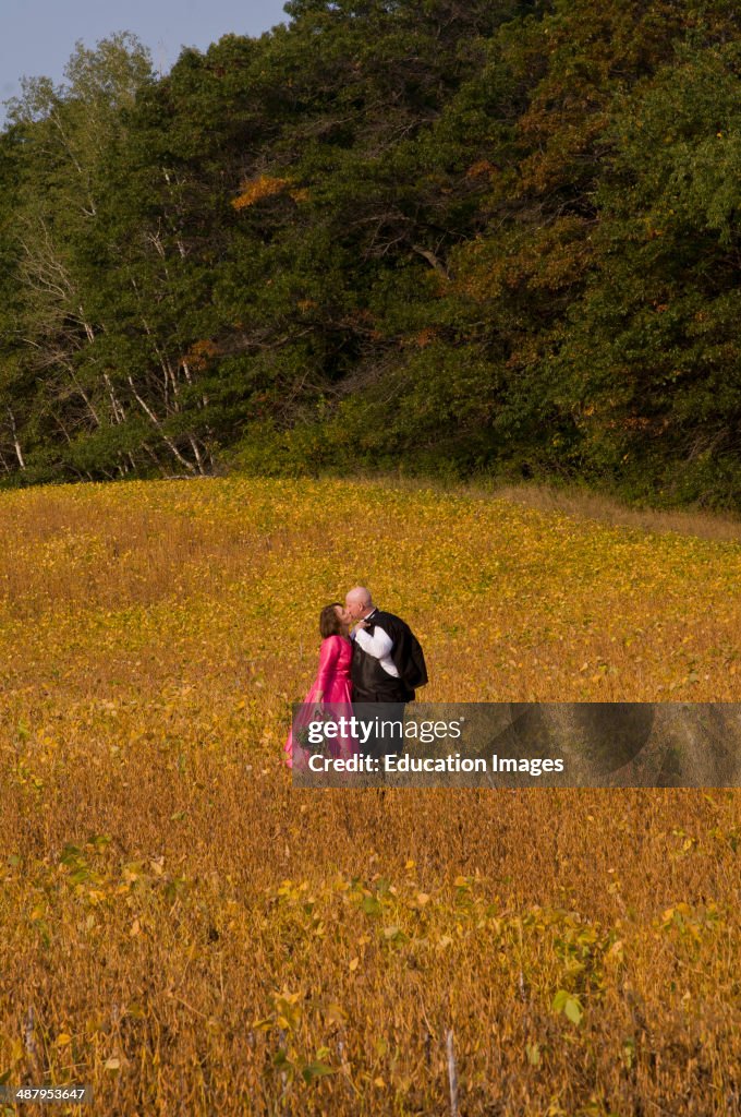 Stillwater, Minnesota, bride and groom in their middle forties on their wedding day kissing in a field