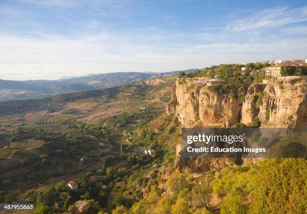 Historic buildings perched on sheer cliff top in Ronda, Spain.