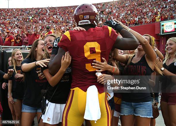 Wide receiver JuJu Smith-Schuster of the USC Trojans is mobbed by a group of students behind the end zone after scoring on a 50 yard touchdown pass...