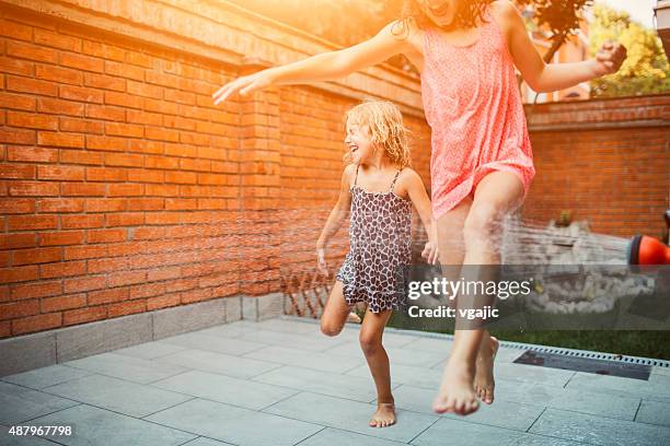 happiness. - jumping sprinkler stock pictures, royalty-free photos & images