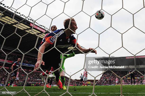 Peter Odemwingie of Stoke City scores despite the efforts of Dan Burn of Fulham on the goal line during the Barclays Premier League match between...