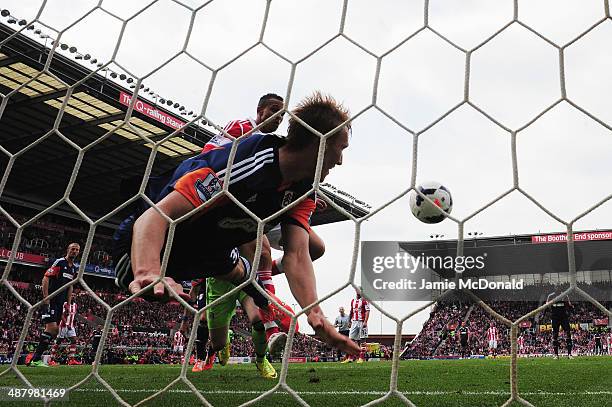 Peter Odemwingie of Stoke City scores despite the efforts of Dan Burn of Fulham on the goal line during the Barclays Premier League match between...