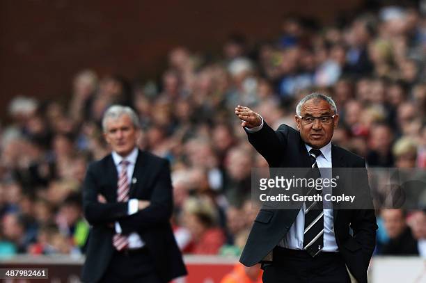 Fulham manager Felix Magath and Mark Hughes the Stoke City manager react on the touchline during the Barclays Premier League match between Stoke City...