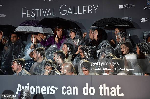 Fans wait out the rain at the "Legend" premiere during the 2015 Toronto International Film Festival at Roy Thomson Hall on September 12, 2015 in...