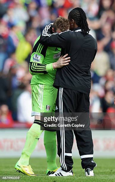 David Stockdale the Fulham goalkeeper is consoled by team mate Hugo Rodallega as they are relegated following their defeat in the Barclays Premier...