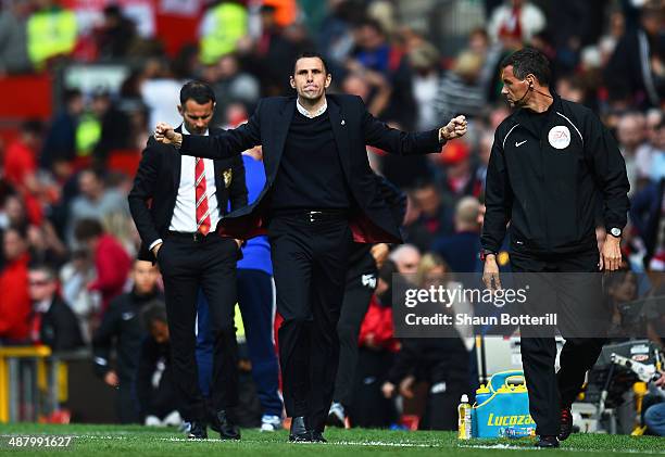 Gustavo Poyet the Sunderland manager celebrates his team's 1-0 victory as a dejected Ryan Giggs the Manchester United interim manager walks behind...