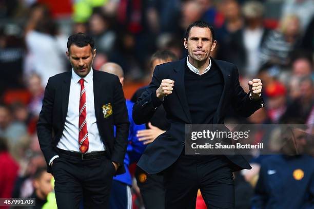 Gustavo Poyet the Sunderland manager celebrates his team's 1-0 victory as a dejected Ryan Giggs the Manchester United interim manager walks behind...