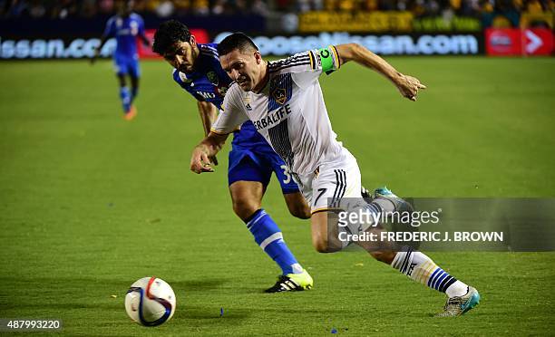 Robbie Keane of the LA Galaxy vies for the ball with Victor Cabrera of the Montreal Impact during their MLS match on September 12, 2015 in Carson,...