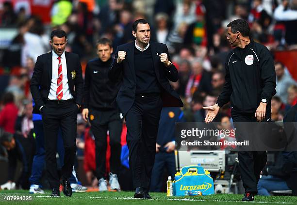 Gustavo Poyet the Sunderland manager celebrates his team's 1-0 victory as a dejected Ryan Giggs the Manchester United interim manager walks behind...