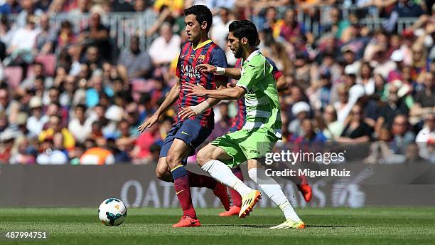 Sergio Busquets of FC Barcelona competes for the ball with Angel Lafita of Getafe CF during the La Liga match between FC Barcelona and Getafe CF at...