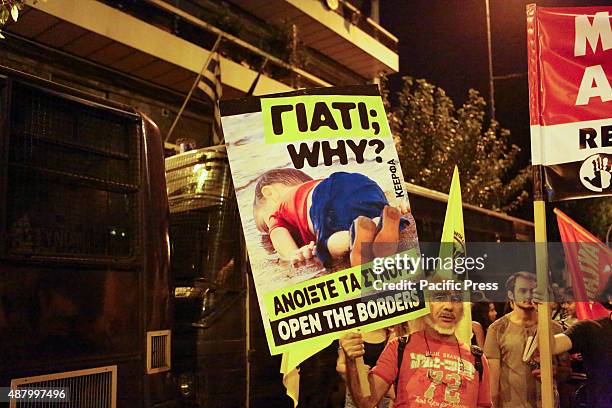Protesters holds up a poster with a picture of the drowned Syrian boy Alan Kurdi outside the European Union Offices in Athens. Greeks marched to the...
