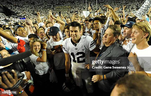 Quarterback Tanner Mangum of the Brigham Young Cougars is surrounded by fans on the field after their 35-24 win over the Boise State Broncos at...