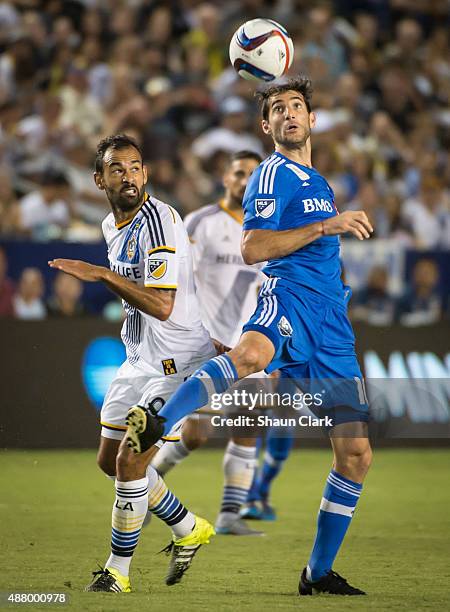 Juninho of Los Angeles Galaxy battles Ignacio Piatti of Montreal Impact during Los Angeles Galaxy's MLS match against Montreal Impact at the StubHub...