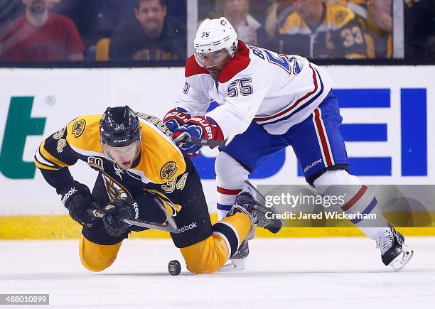Carl Soderberg of the Boston Bruins is checked from behind with the puck by Francis Bouillon of the Montreal Canadiens in the second period in Game...