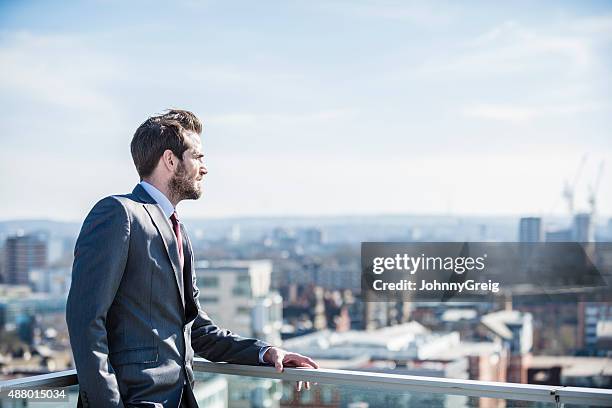 pensive city businessman looking to horizon - balcony view stockfoto's en -beelden