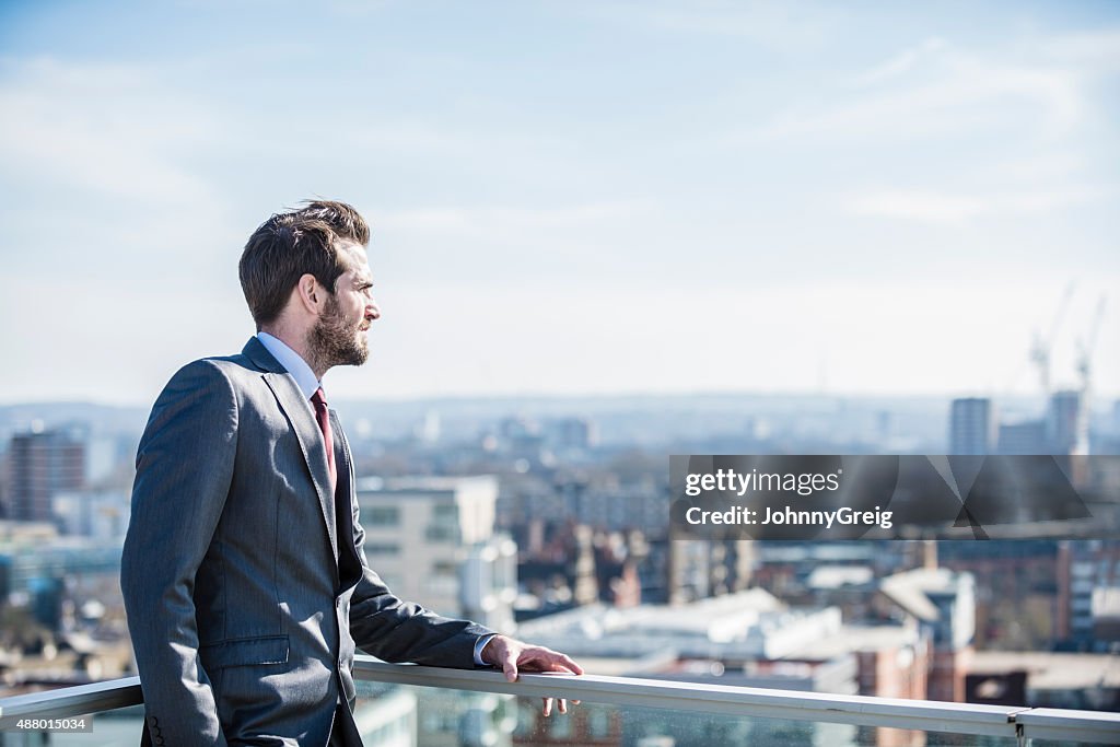Pensive city businessman looking to horizon