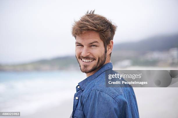 pflege, um mich bei einem spaziergang am strand? - portrait of handsome man stock-fotos und bilder