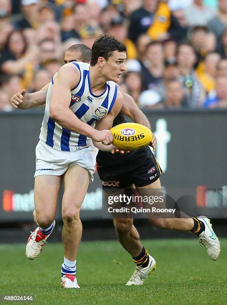 Scott Thompson of the Kangaroos handballs whilst being tackled by Bachar Houli of the Tigers during the First AFL Elimination Final match between the...
