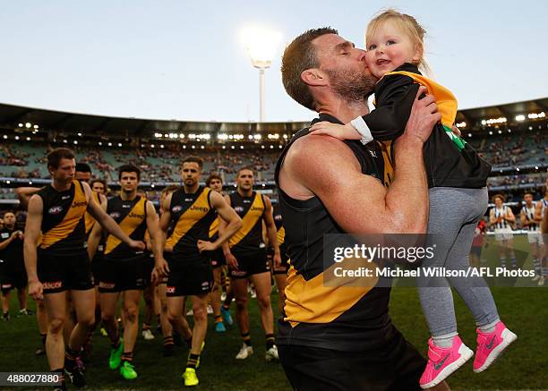 Chris Newman of the Tigers walks from the field after his last match with his daughter during the 2015 AFL First Elimination Final match between the...