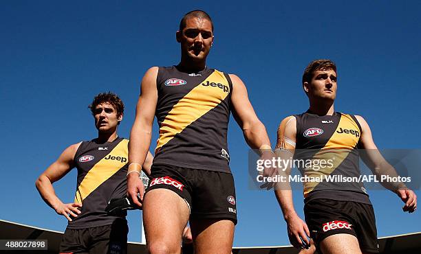 Ben Griffiths, Shaun Grigg and Anthony Miles of the Tigers walk to line up for the national anthem during the 2015 AFL First Elimination Final match...