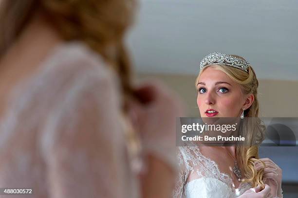 Amira Rayner adjusts her hair ahead of the Queen Charlotte Ball on September 11, 2015 in London, England. Queen Charlotte's Ball is the pinnacle...