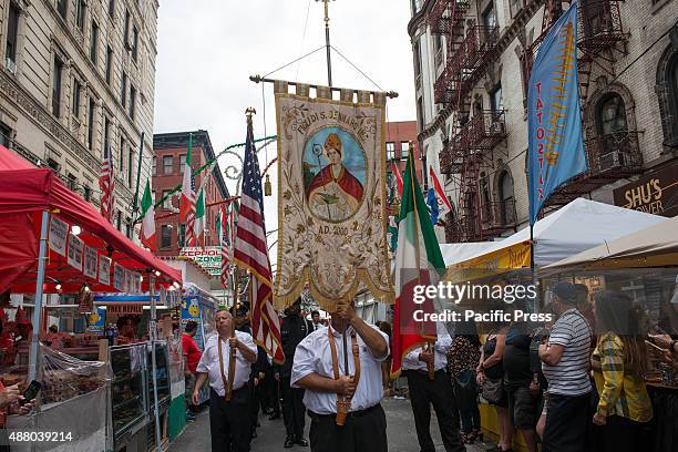 The banner for the Feast of San Gennaro and color guardsmen pass process through Mulberry Street. The eleven-day festival of San Gennaro, now in its...