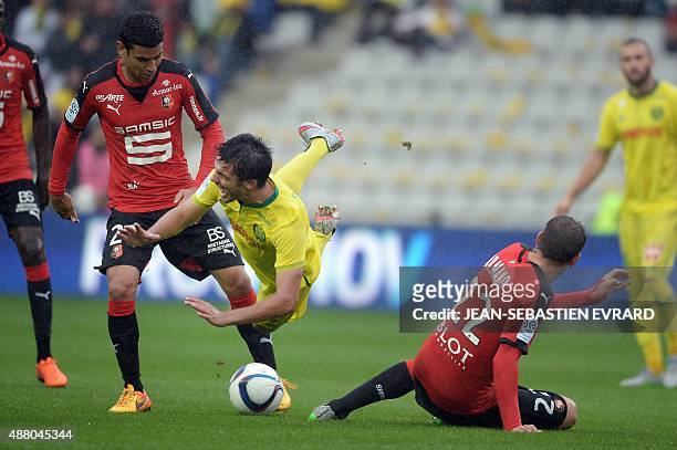 Nantes' French defender Leo Dubois is tackled by Rennes' French defender Sylvain Armand during the French L1 football match between Nantes and Rennes...