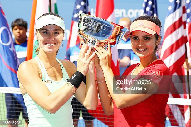 Martina Hingis of Switzerland and Sania Mirza of India celebrate with the winner's trophy after defeating Casey Dellacqua of Australia and Yaroslava...