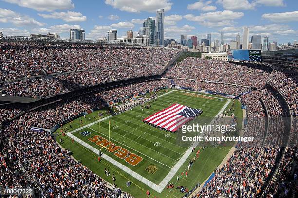 The national anthem is sung as a stealth bomber flies overhead during the pre-game ceremonies of the game between the Chicago Bears and the Green Bay...
