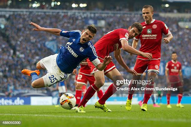 Klaas-Jan Huntelaar of Schalke is challenged by Stefan Bell and Pierre Bengtsson of Mainz during the Bundesliga match between FC Schalke 04 and 1....