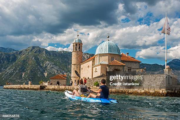 couple kayaking in front of our lady of the rocks - our lady of the rocks stock pictures, royalty-free photos & images