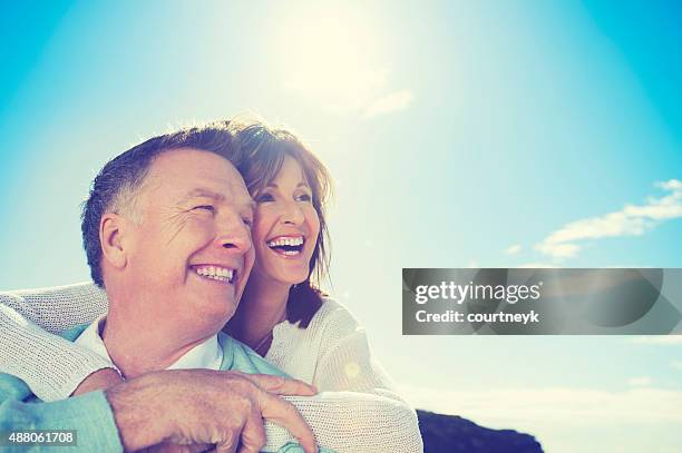 happy loving mature couple on the beach. - tooth bonding stock pictures, royalty-free photos & images