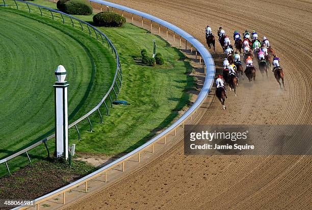 The field of horses rounds the first turn during the 140th running of the Kentucky Derby at Churchill Downs on May 3, 2014 in Louisville, Kentucky.