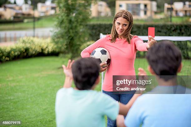 mother telling off her sons while playing football - spelregels stockfoto's en -beelden