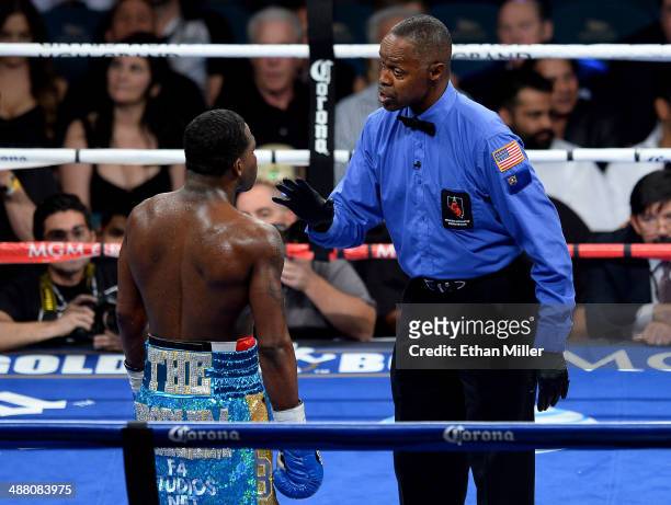 Referee Kenny Bayless talks with Adrien Broner after he is warned for throwing down Carlos Molina during their super lightweight bout at the MGM...