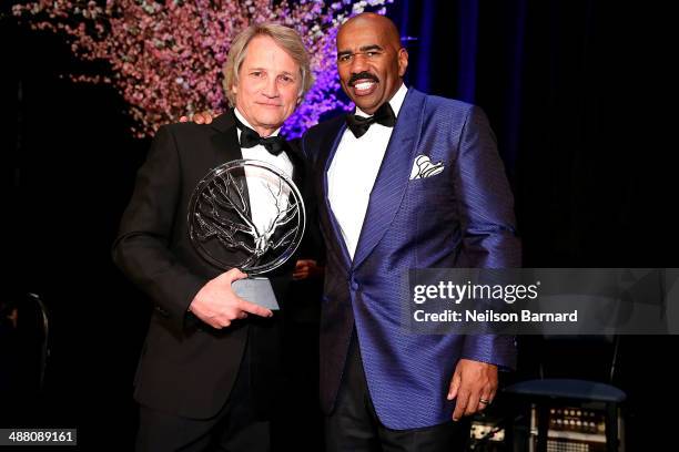 Clint Culpepper, President of Screen Gems accepts an award from Steve Harvey on stage at the 2014 Steve & Marjorie Harvey Foundation Gala presented...