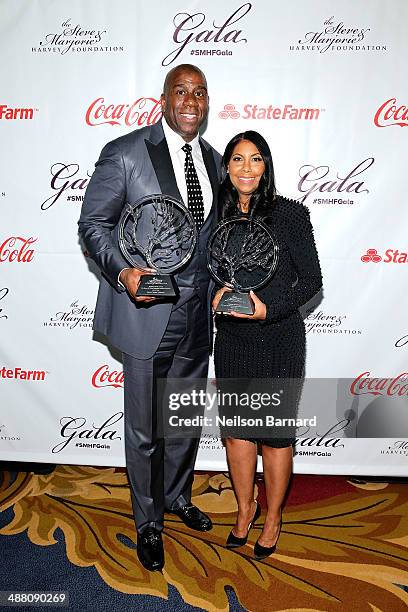 Earvin "Magic" Johnson and Cookie Johnson poses with their awards at the 2014 Steve & Marjorie Harvey Foundation Gala presented by Coca-Cola at the...