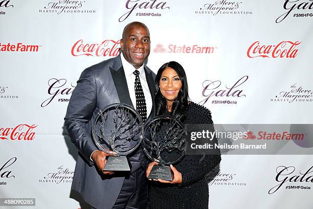 Earvin "Magic" Johnson and Cookie Johnson poses with their awards at the 2014 Steve & Marjorie Harvey Foundation Gala presented by Coca-Cola at the...