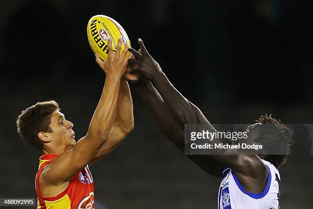 Sean Lemmens of the Suns and Majak Daw of the Kangaroos contest for the ball during the round seven AFL match between the North Melbourne Kangaroos...