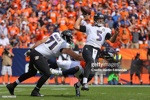 Quarterback Joe Flacco of the Baltimore Ravens is sacked by linebacker DeMarcus Ware of the Denver Broncos as tackle Ricky Wagner attempts to block...