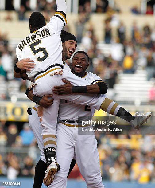 Josh Harrison of the Pittsburgh Pirates celebrates with Sean Rodriguez and Gregory Polanco after hitting a walk off single in the eleventh inning...