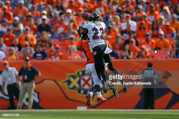 Cornerback Jimmy Smith of the Baltimore Ravens breaks up a pass intended for wide receiver Jordan Norwood of the Denver Broncos before intercepting...