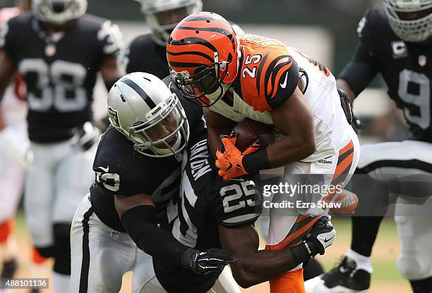 Malcolm Smith and D.J. Hayden of the Oakland Raiders tackle Giovani Bernard of the Cincinnati Bengals during the first half of their NFL game at O.co...